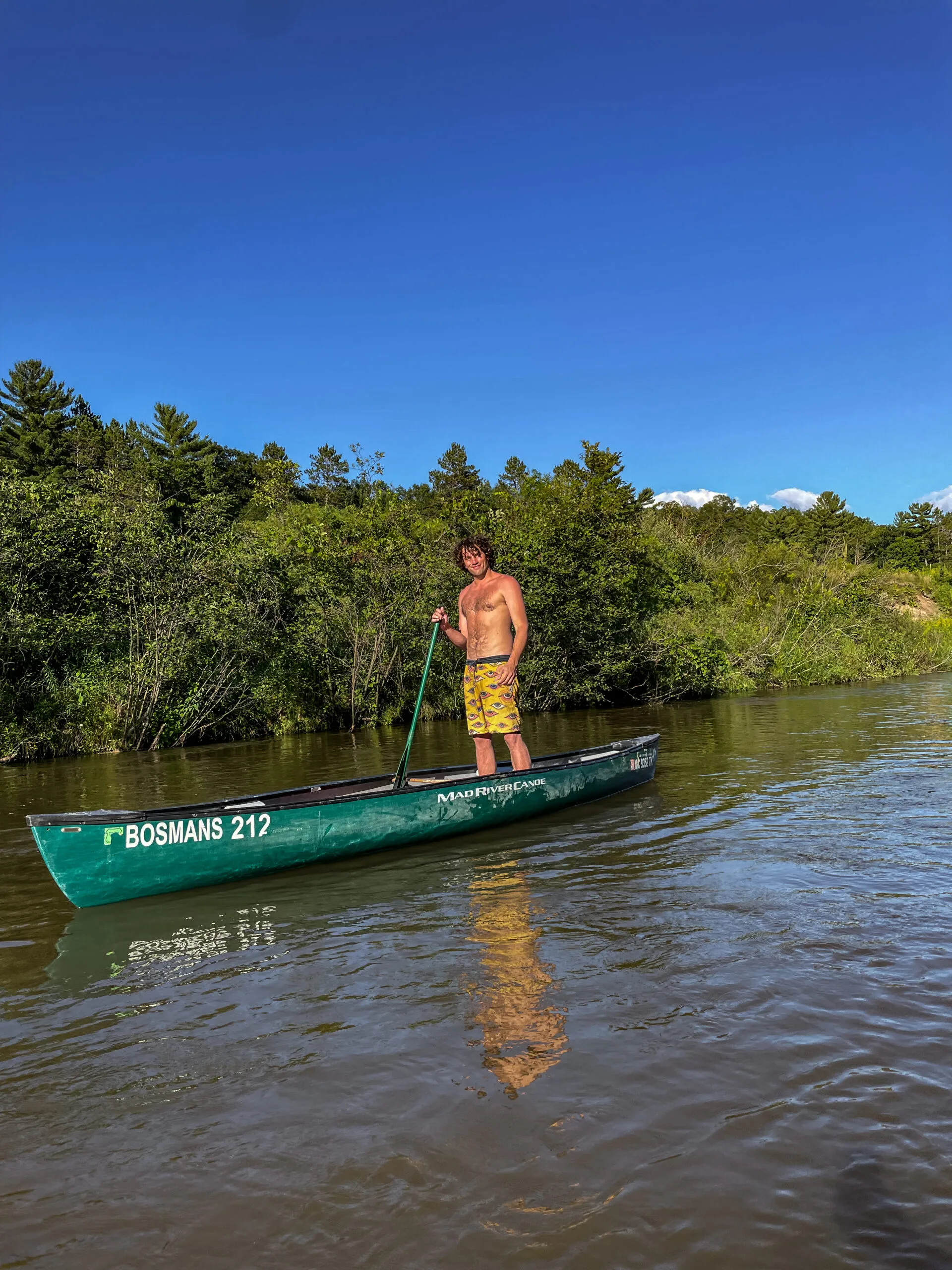 man stands in canoe